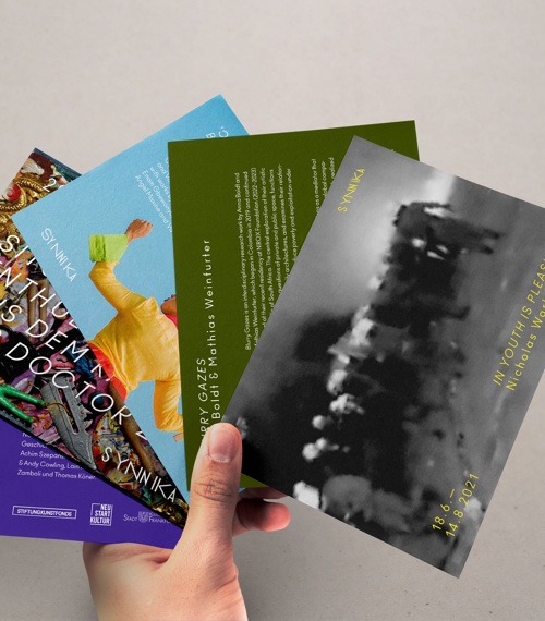 Eine Hand hält unterschiedliche Synnika-Flyer